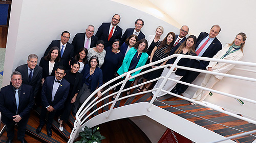 Reitores participantes da assembleia geral do Hemispheric University Consortium (HUC), realizada na Casa do Professor Visitante (CPV) da Unicamp, posam em pé, em diferentes degraus de uma escada, para foto tirada do alto.