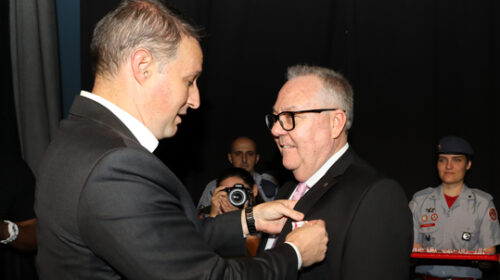 Secretário de Segurança Pública do Estado de São Paulo, Guilherme Derrite, fixa medalha na lapela do terno do reitor Paulo Cesar Montagner.