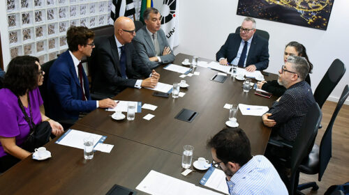 Reitor Paulo Cesar Montagner sentado à cabeceira de mesa de sala de reuniões na companhia de representantes da École des Hautes Études en Sciences Sociales, da França, e da Diretoria Executiva de Relações Internacionais (Deri) da Unicamp.