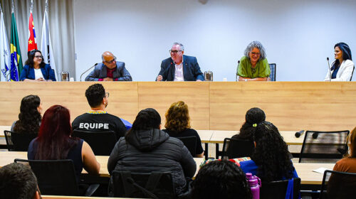 Vista frontal da mesa de autoridades de um auditório, à estão sentadas cinco pessoas, das quais três mulheres e dois homens. O reitor da Unicamp, Paulo Cesar Montagner, está na posição central.