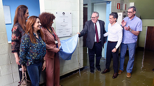 Três mulheres, à esquerda, e três homens, à direita, entre os quais o reitor da Unicamp, Paulo Cesar Montagner, descerram placa de inauguração, fixada em parede branca, que estava coberta por tecido azul.