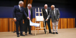 Quatro homens descerram placa apoiada em cavalete e coberta com tecido azul claro. O reitor da Unicamp, Paulo Cesar Montagner, é o segundo da esquerda para a direita; o coordenador geral da Universidade, Fernando Coelho, o quarto.